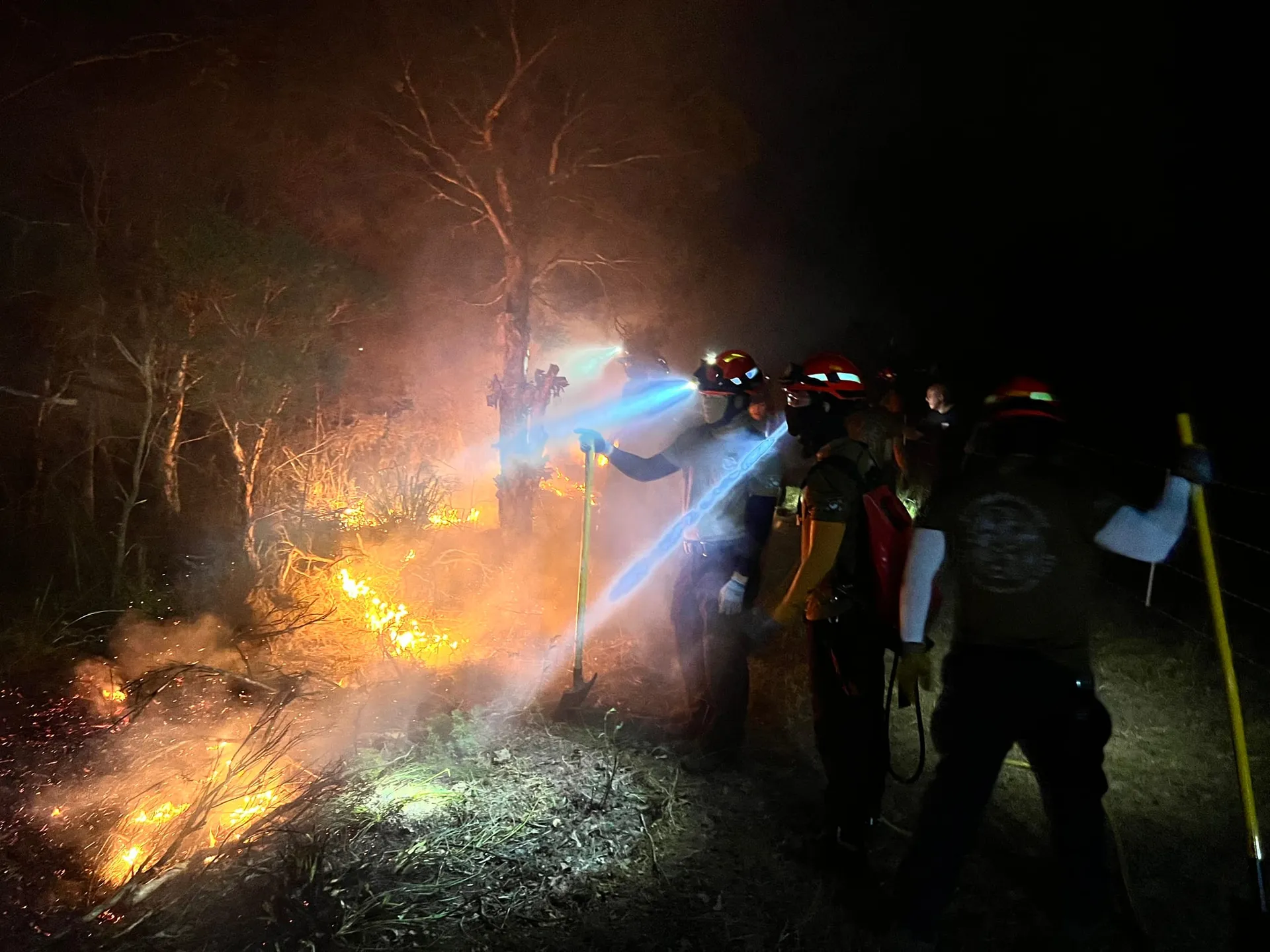 Crew working a night burn by head torch
