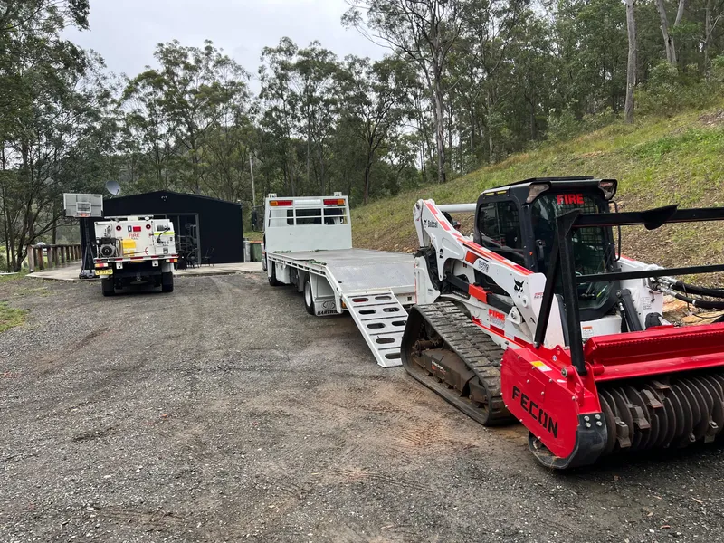Tracked mulching plant being loaded onto a float